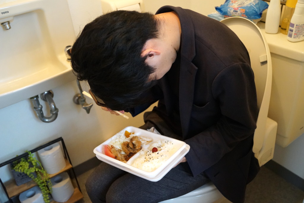 【フリー画像素材】トイレで食べるご飯が嫌になってしまった男性 フリー素材のAPhoto（アフォト）