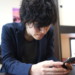 真剣な顔でスマホを操作する男性