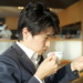 コーヒーを飲みながらニュースをチェックするビジネスマン
