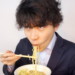 ラーメンをすする男性