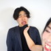 笑顔で男性の胸ぐらを掴む女性