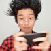 余裕の表情でスマホゲームをプレイするオタク