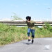何かのキャラに扮して河川敷を走る男子