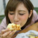 幸せそうにピザを食べる女性